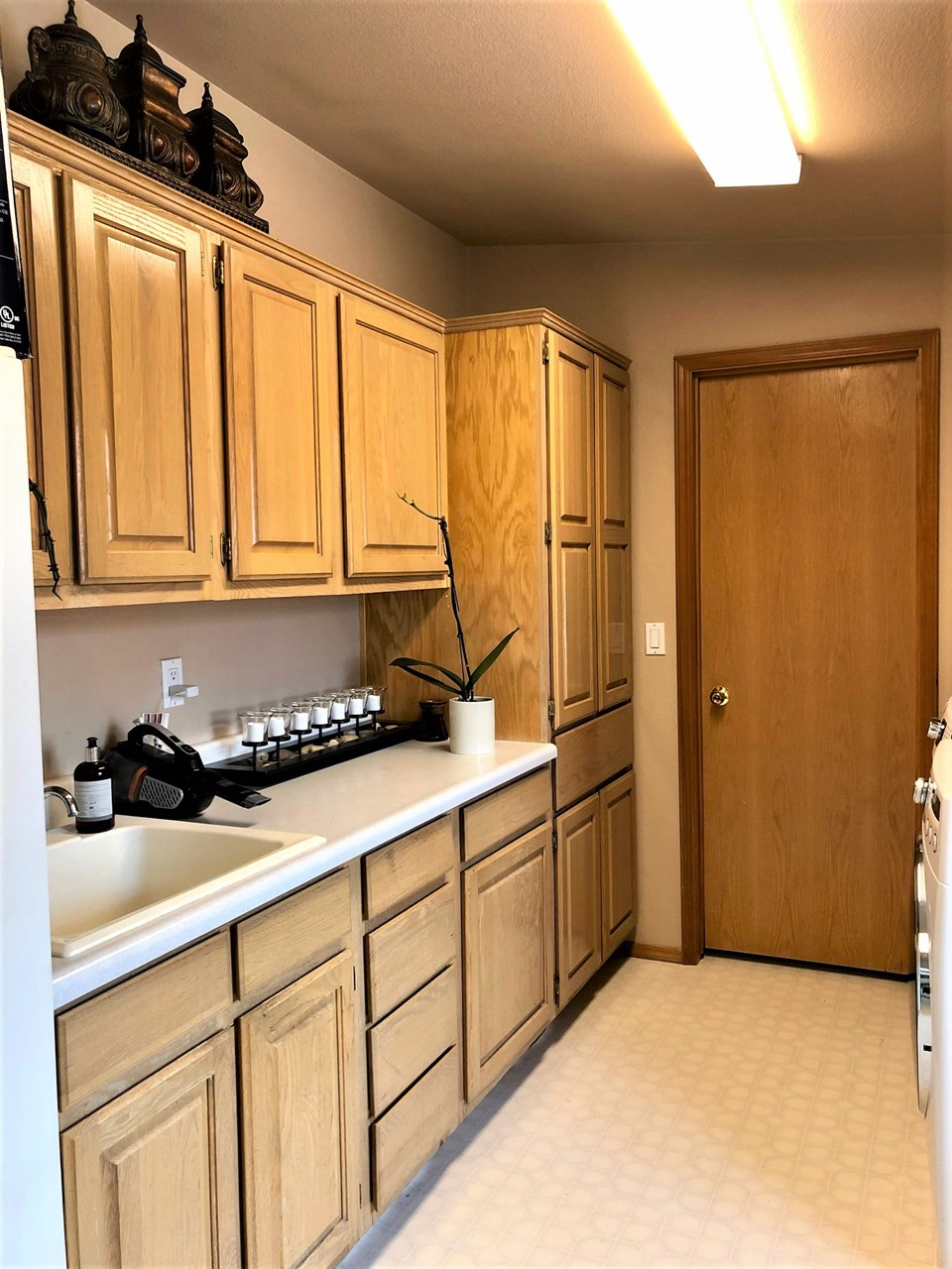 abundance of cupboard space and wash basin in laundry area